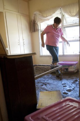 Donna Lamb inspects flood damage at a Mitchell house.