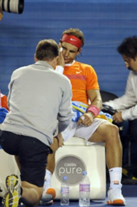 The trainer works on Rafael Nadal's knee on Tuesday night.