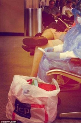 A woman wears a Hazmat suit at a US airport: it's unclear whether it was a stunt.