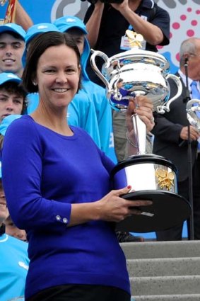 Former champion Lindsay Davenport holds the women's trophy.