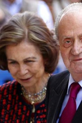 Spain's King Juan Carlos (right) waves beside Queen Sofia. The 75-year-old king has had a spectacular fall from grace as scandals undermine his public approval.