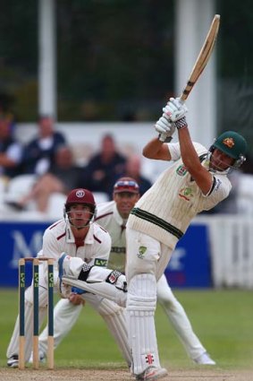 Usman Khawaja hits a four over midwicket as wicketkeeper Alex Barrow of Somerset looks on.