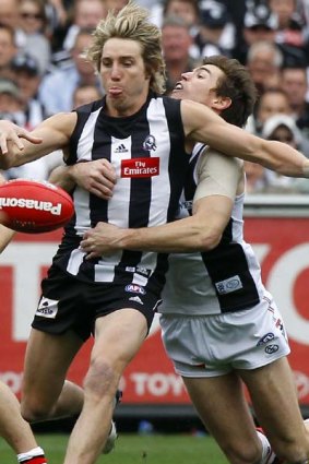Saints midfielder Lenny Hayes applies a desperate tackle to his Magpies opponent Dale Thomas.