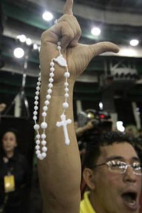 Tribute...a supporter in Manila show the "L" sign for Laban (fight), which Corazon Aquino often used.