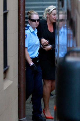 Keli Lane being lead away by a security officer from the Supreme Court.