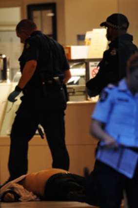 A man’s body lies in a bar in Lygon Street.