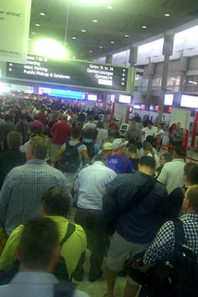 Passengers queue after Brisbane Airport's domestic terminal was evacuated this afternoon.
