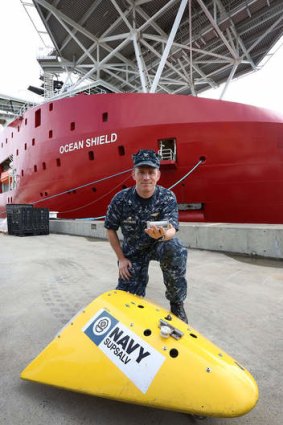 US Navy Captain Mark Matthews with an Acoustic Pinger with a Towed Pinger Locater in front of ADV Ocean Shield at HMAS Stirling, Garden Island in Perth.
