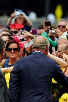 Crowd favourite ... Prince Charles greets racegoers upon his arrival at Flemington. He later presented the Diamond Jubilee Plate, named in honour of the Queen.
