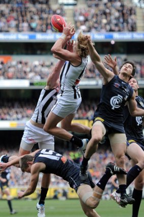 Collingwood's Dale Thomas taking a big mark over Carlton's Jeremy Laider. Picture by Mal Fairclough