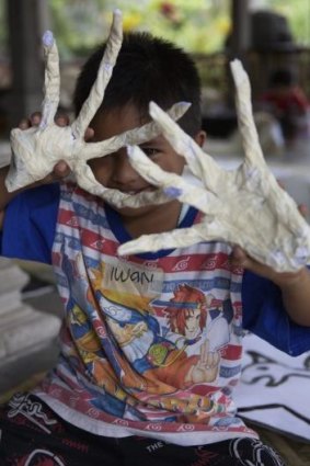 A child from a remote Indonesian community creates puppets during a visit by members of Melbourne's Polyglot Theatre.