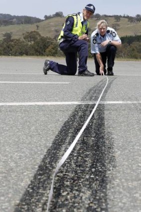Sergeant Dick Dauth and Senior Constable Jane MacKenzie from Collision Investigation and Reconstruction Team measuring skid marks during training at the Australian Federal Police Training Facility.