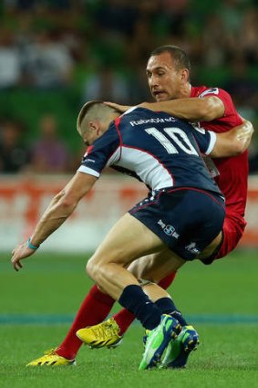 Caught: James O'Connor goes in with a strong tackle on Quade Cooper.