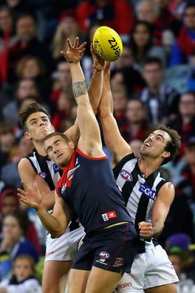 Lopsided contest: Melbourne's Dean Kent is outnumbered by Paul Seedsman and Steele Sidebottom of Collingwood.