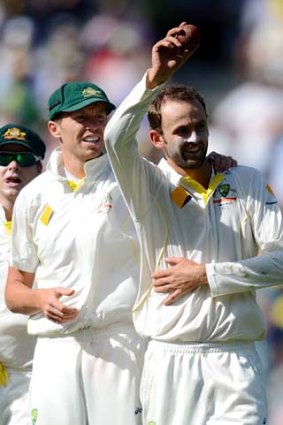 Nathan Lyon shows the ball to the crowd after achieving the twin marks of five wickets in England's innings and 100 wickets as a Test bowler.