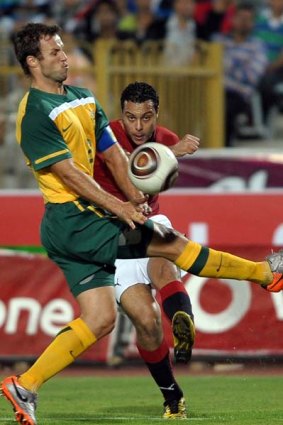 Ahmed Abdul Malek of Egypt beats Socceroos captain Lucas Neill to the ball.