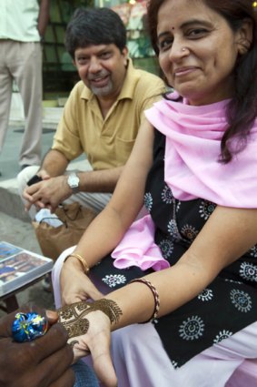 Sheetal Sharma watches as his wife Anu's hands are decorated in Delhi.