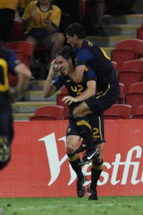 Mark Milligan of Australia celebrates his winning goal with teammate Simon Colosimo.