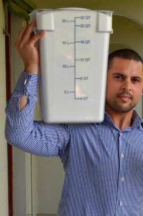 Craig Padayachee with a container holding the amount of sugar you would consume if you drank a can of soft drink every day for a year.