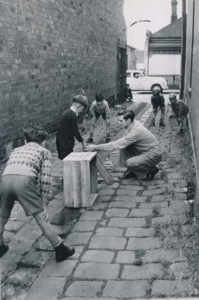 Neil Harvey on a 1950 visit to the lane beside his family home in Argyle Street, giving local children a few tips.