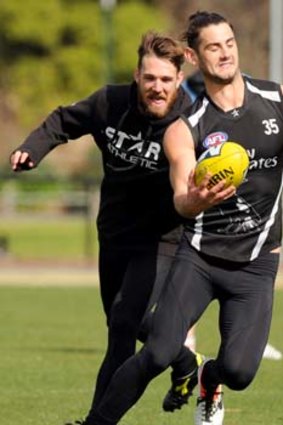 Come here: Magpie star Dane Swan has trouble reeling in young ruckman Brodie Grundy at Collingwood training on Thursday.