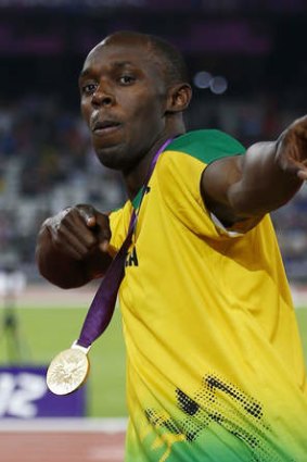 Usain Bolt poses with the 200m gold medal at the  London Olympics.