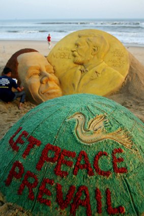 Indian artist Sudersan Pattnaik gives final touches to a sand sculpture of  Barack Obama at Golden Sea Beach in Puri.