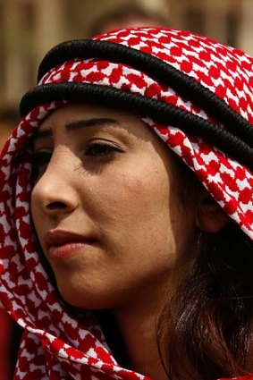 A woman in a traditional keffiyeh headscarf.