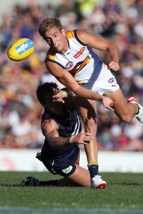 Eagles' Brad Sheppard of handballs before being tackled by Michael Barlow during the round-one derby.
