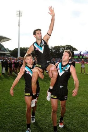 Port Adelaide's Dom Cassisi is chaired off the ground.