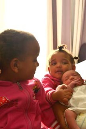 Mother's Day baby Aron Mengistu meets sisters Rachel (left) and Meron under the watchful eye of their mother Abrehet.