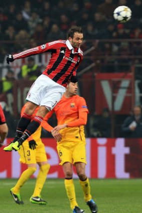 High flyer ... AC Milan's Giampaolo Pazzini jumps for the ball during their Champions League match against Barcelona at the San Siro stadium in Milan.