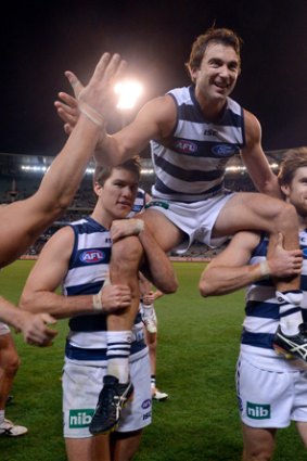 Geelong's Corey Enright, celebrating his 250th AFL game, is carried off by teammates Andrew Mackie and Tom Lonergan.