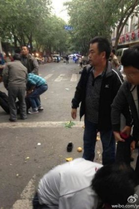 People reacting to the explosions in a marketplace in Urumqi. (Via Weibo)