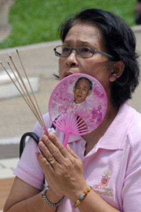 A well-wisher prays for the Thai King.