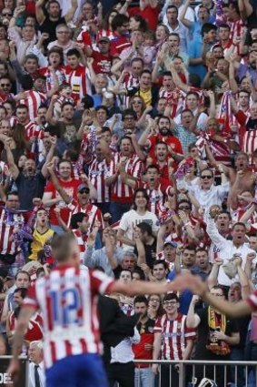 Atletico Madrid's supporters celebrate after their team scored against Malaga CF.