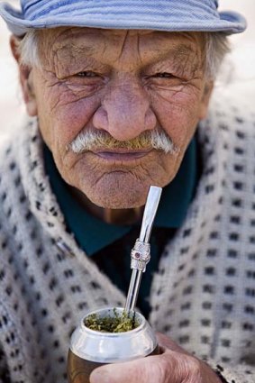 The bitter-herb beverage of mate, drunk through a metal straw.