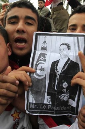 Tunisian protesters chant as they hold a photograph of Mohammed Bouazizi in January 2011.