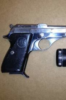 The Beretta pistol with black silencer.