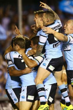 Jubilation: Sharks players celebrate after Andrew Fifita's try against the Titans.