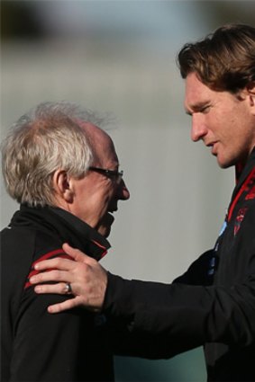 James Hird embraces Dr Bruce Reid at Bombers training on Monday.