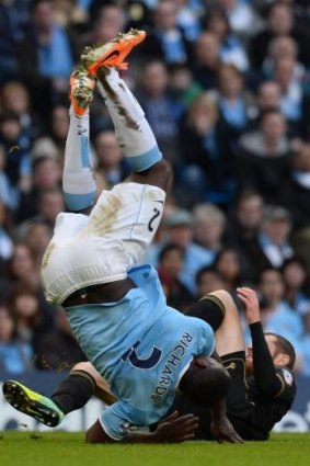 Tumbling in: Manchester City's defender Micah Richards is tackled by Wigan's midfielder Chris McCann.