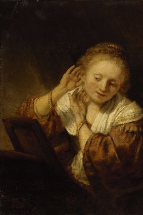 Rembrandt's Young woman trying on earrings, 1657, is among items from Russia's Hermitage to go on show in Melbourne.