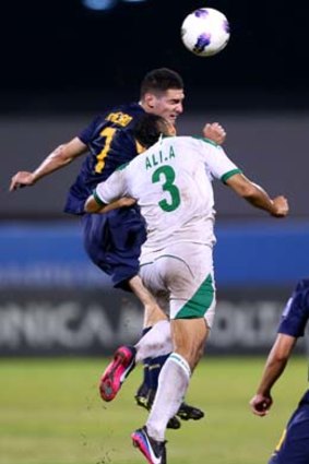 Iraq's Ali Kadhim contests the ball with Corey Gameiro.