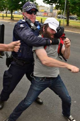 Police grab a protester.