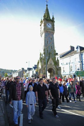 Resilience ... hundreds of Machynlleth residents walk together to St Peter's Church for yesterday's service.