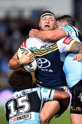 Tariq Sims of the Cowboys is tackled by Junior Roqica and Chris Heighington of the Sharks.