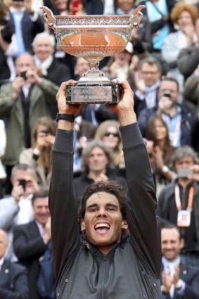 Rafael Nadal raises the trophy after defeating Novak Djokovic.