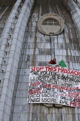 Italian businessman Marcello di Finizio stands by his banner with writings against the Italian Government and the Euro as he protests on St. Peter's 137-metre-high dome, at the Vatican.