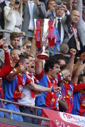 Australian-born Crystal Palace skipper Mile Jedinak raises the English Championship play-off trophy.